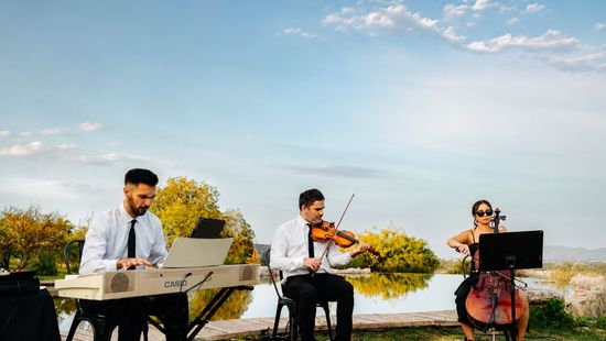 Trío de Tempo Urbano tocando junto a un espejo de agua