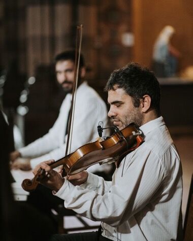Violinista y pianista tocando en una iglesia
