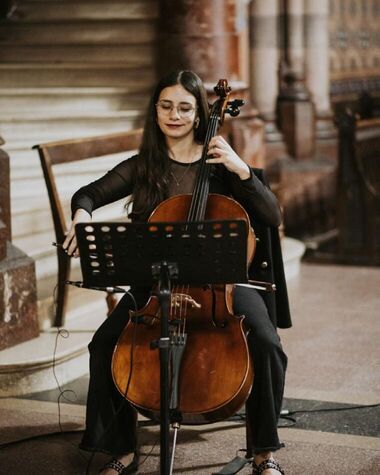 Violonchelista de Tempo Urbano tocando en la escalinata de una iglesia