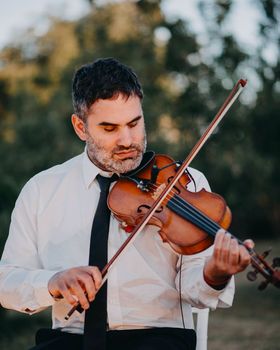 Violinista tocando con luz de atardecer