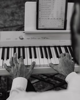 Manos tocando el piano junto a la lista de temas